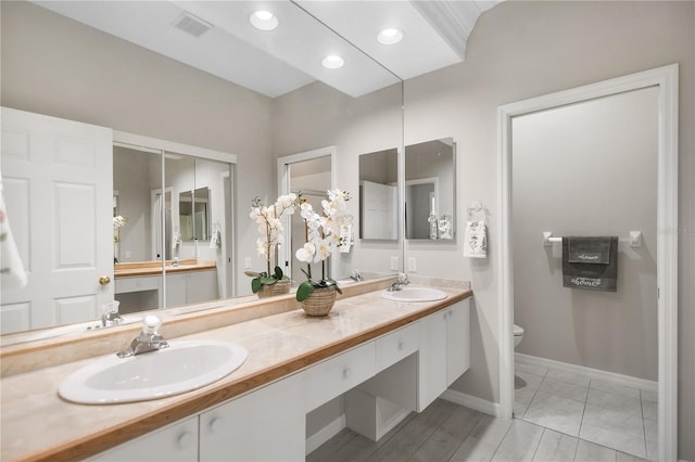 8525 54th Avenue Cir E, Bradenton, FL 34211 - bathroom with toilet, double vanity, baseboards, and recessed lighting