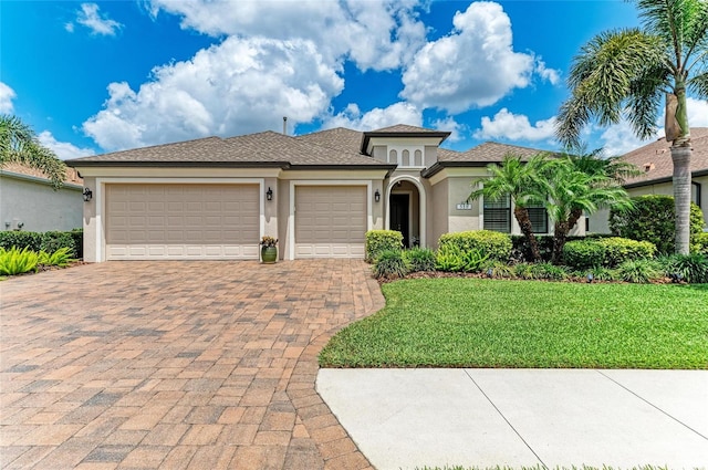518 Chantilly Trl, Bradenton, FL 34212 - mediterranean / spanish-style home with stucco siding, an attached garage, decorative driveway, and a front yard