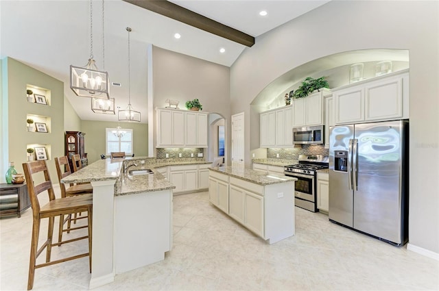 518 Chantilly Trl, Bradenton, FL 34212 - kitchen featuring appliances with stainless steel finishes, a chandelier, tasteful backsplash, a center island, and high vaulted ceiling