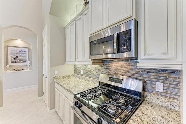 518 Chantilly Trl, Bradenton, FL 34212 - kitchen with appliances with stainless steel finishes, tasteful backsplash, light stone counters, and white cabinetry