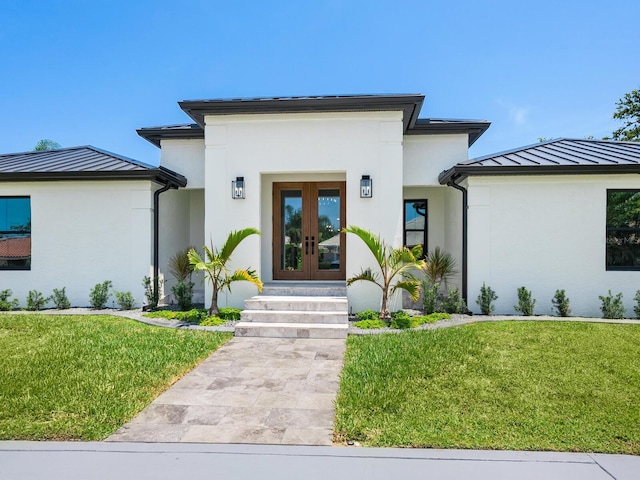 180 Lookout Point Dr, Osprey, FL 34229 - view of front of property with french doors, stucco siding, a standing seam roof, and a front yard