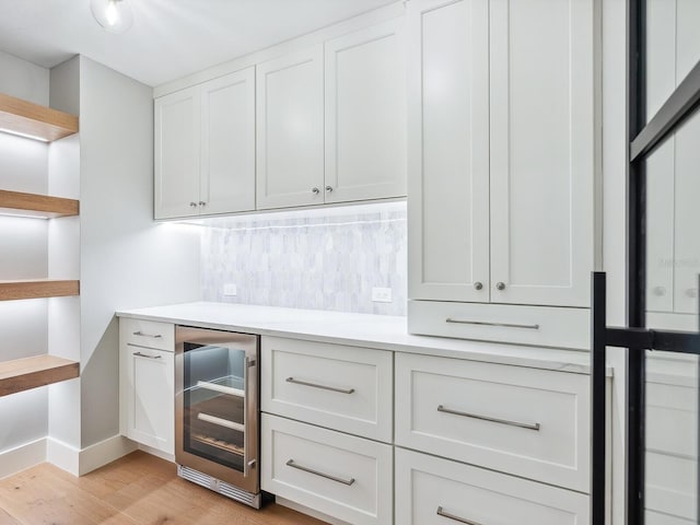 180 Lookout Point Dr, Osprey, FL 34229 - indoor dry bar with wine cooler, light wood-style floors, and backsplash