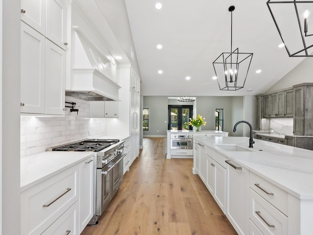 180 Lookout Point Dr, Osprey, FL 34229 - kitchen with double oven range, tasteful backsplash, recessed lighting, a kitchen island with sink, and light wood-type flooring