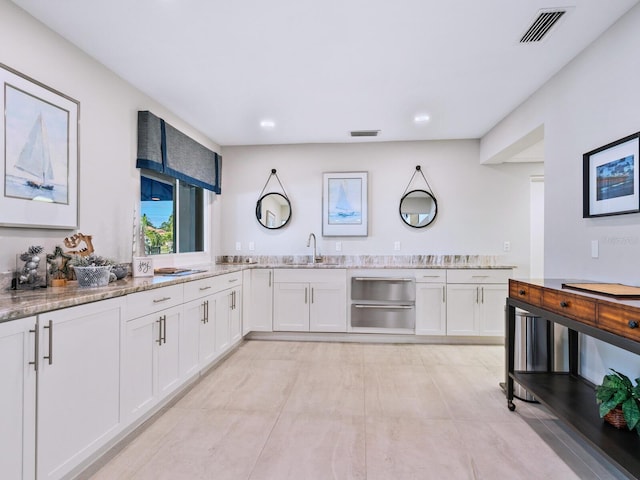 180 Lookout Point Dr, Osprey, FL 34229 - kitchen with white cabinetry, light stone counters, a warming drawer, and recessed lighting