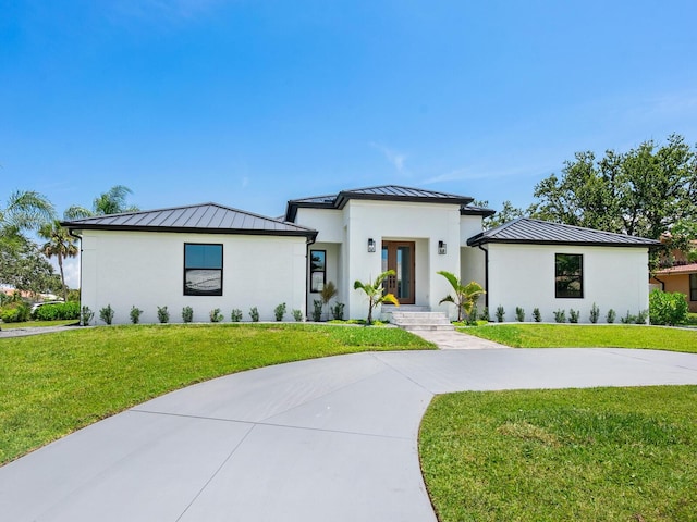 180 Lookout Point Dr, Osprey, FL 34229 - view of front of home featuring a standing seam roof, a metal roof, a front lawn, and stucco siding