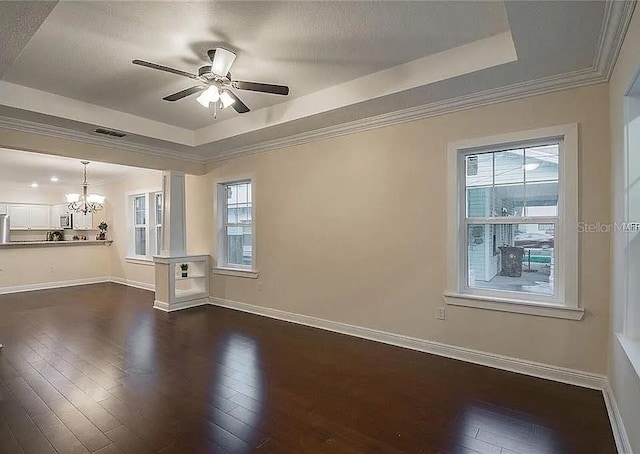 1420 E Frierson Ave, Tampa, FL 33603 - empty room featuring a raised ceiling, dark wood-style floors, plenty of natural light, and crown molding