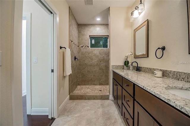 1420 E Frierson Ave, Tampa, FL 33603 - bathroom with a walk in shower, double vanity, and baseboards
