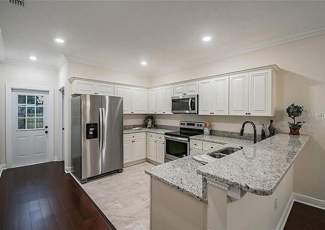 1420 E Frierson Ave, Tampa, FL 33603 - kitchen with stainless steel appliances, a peninsula, a sink, light stone countertops, and white cabinets