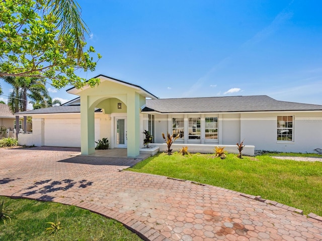 7779 Holiday Dr N, Sarasota, FL 34231 - ranch-style home featuring a garage, stucco siding, decorative driveway, and a front yard