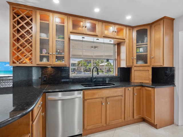 7779 Holiday Dr N, Sarasota, FL 34231 - kitchen with stainless steel dishwasher, a sink, dark stone countertops, decorative backsplash, and light tile patterned floors