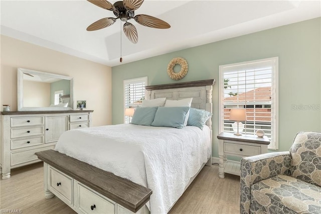 10202 L Pavia Blvd Unit 10202, Venice, FL 34292 - bedroom with light wood-type flooring, a tray ceiling, and a ceiling fan