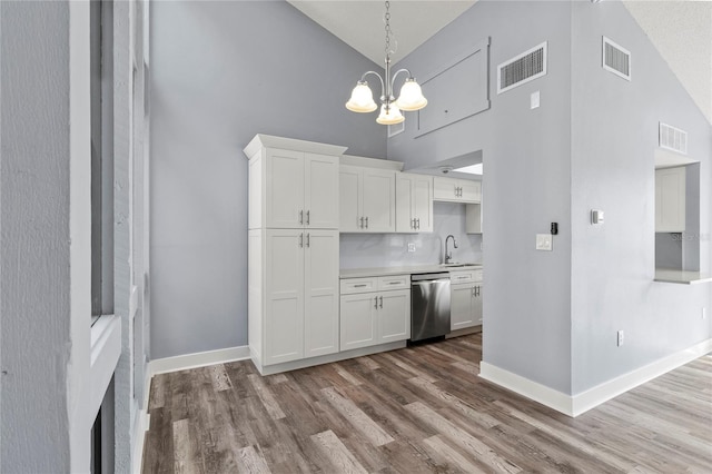 800 S Blvd Of The Presidents Unit 5, Sarasota, FL 34236 - kitchen with stainless steel dishwasher, high vaulted ceiling, a chandelier, wood finished floors, and white cabinets