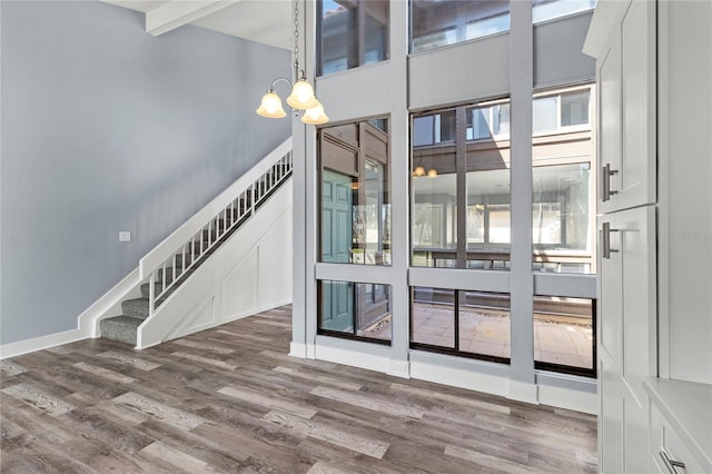 800 S Blvd Of The Presidents Unit 5, Sarasota, FL 34236 - empty room with a chandelier, wood finished floors, stairway, and a towering ceiling