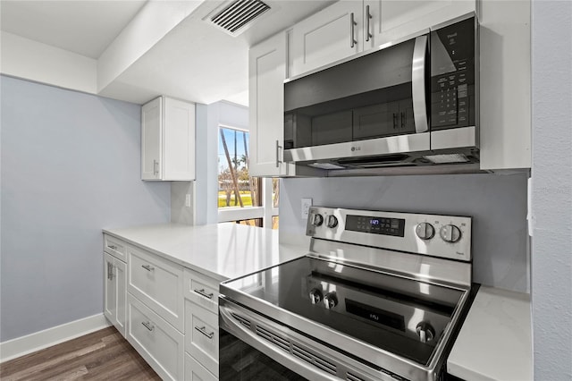 800 S Blvd Of The Presidents Unit 5, Sarasota, FL 34236 - kitchen featuring stainless steel appliances, white cabinets, light countertops, dark wood finished floors, and baseboards
