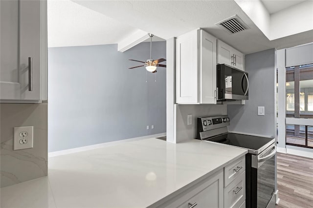 800 S Blvd Of The Presidents Unit 5, Sarasota, FL 34236 - kitchen with stainless steel appliances, ceiling fan, white cabinets, light countertops, and beam ceiling