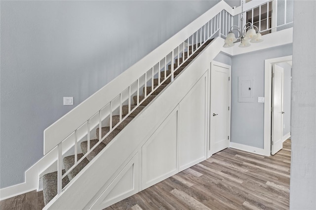 800 S Blvd Of The Presidents Unit 5, Sarasota, FL 34236 - stairway featuring a chandelier, wood finished floors, and baseboards