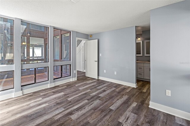 800 S Blvd Of The Presidents Unit 5, Sarasota, FL 34236 - unfurnished bedroom featuring dark wood-type flooring, baseboards, and a textured ceiling