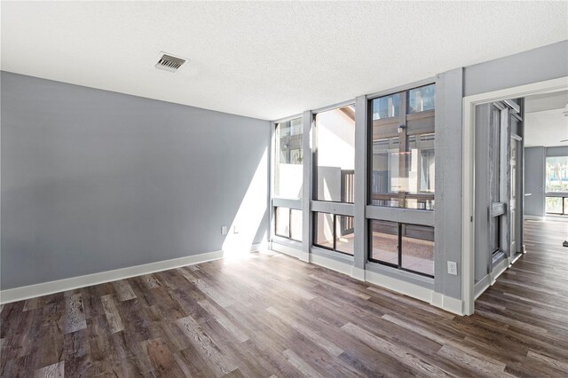 800 S Blvd Of The Presidents Unit 5, Sarasota, FL 34236 - empty room featuring dark wood-style flooring, baseboards, and a textured ceiling