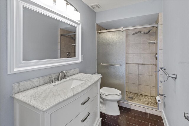 800 S Blvd Of The Presidents Unit 5, Sarasota, FL 34236 - full bath with a stall shower, wood finish floors, toilet, and vanity