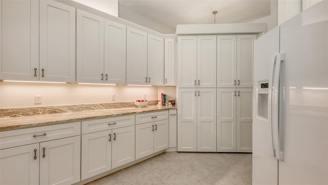 4208 Balmoral Way, Sarasota, FL 34238 - kitchen with white refrigerator with ice dispenser, white cabinets, light tile patterned floors, and light stone countertops