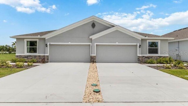 18109 Cropside Trl, Lakewood Ranch, FL 34211 - ranch-style home with stone siding, a garage, driveway, and stucco siding