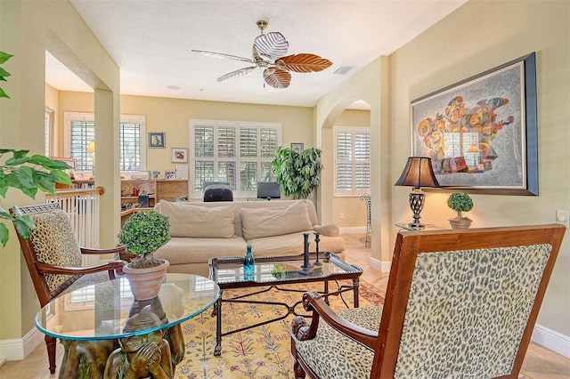 6552 Moorings Point Cir Unit 201, Lakewood Ranch, FL 34202 - living room with baseboards, light tile patterned floors, arched walkways, and ceiling fan