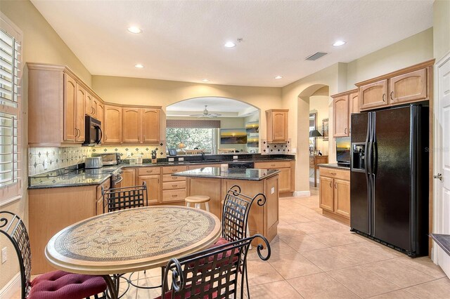 6552 Moorings Point Cir Unit 201, Lakewood Ranch, FL 34202 - kitchen featuring black appliances, arched walkways, backsplash, a sink, and light tile patterned floors