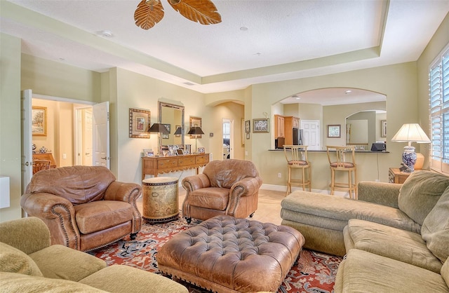 6552 Moorings Point Cir Unit 201, Lakewood Ranch, FL 34202 - living room featuring arched walkways, light tile patterned floors, and baseboards