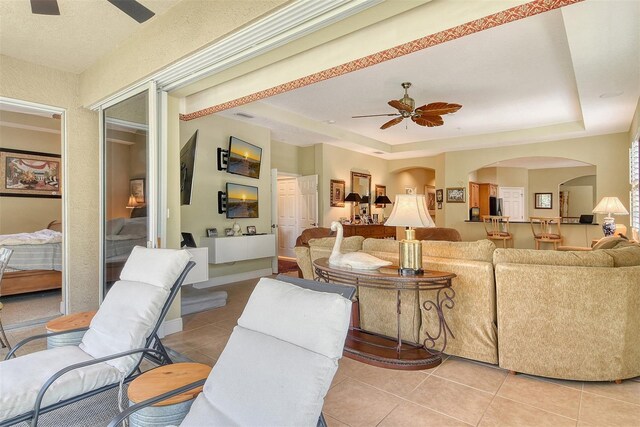 6552 Moorings Point Cir Unit 201, Lakewood Ranch, FL 34202 - living room featuring ceiling fan, light tile patterned floors, a raised ceiling, and arched walkways