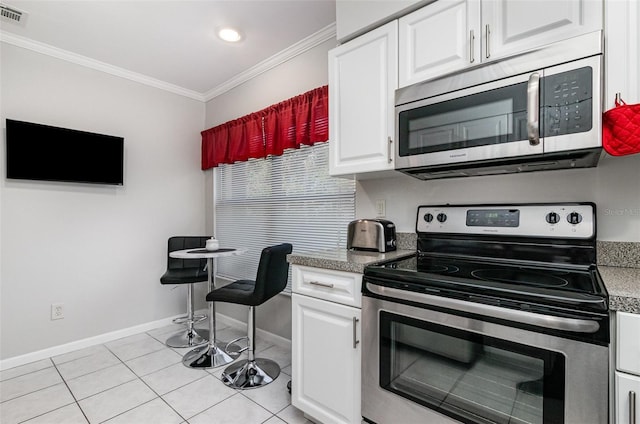 716 SE 12th Ct Unit 31, Cape Coral, FL 33990 - kitchen featuring appliances with stainless steel finishes, ornamental molding, baseboards, white cabinets, and light tile patterned floors