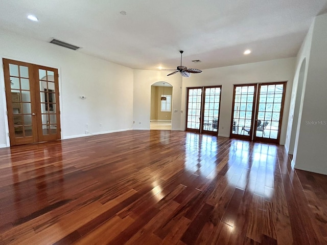 13809 18th Pl E, Bradenton, FL 34212 - unfurnished living room featuring french doors, arched walkways, dark wood finished floors, ceiling fan, and recessed lighting