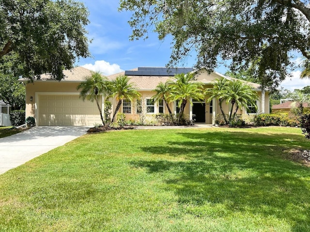 13809 18th Pl E, Bradenton, FL 34212 - view of front of house featuring an attached garage, a front lawn, roof mounted solar panels, concrete driveway, and stucco siding