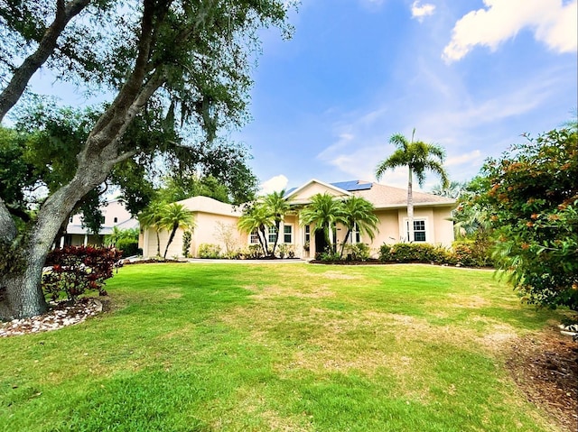 13809 18th Pl E, Bradenton, FL 34212 - view of front of house featuring stucco siding, roof mounted solar panels, and a front yard