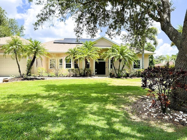 13809 18th Pl E, Bradenton, FL 34212 - view of front of house featuring a garage, roof mounted solar panels, a front yard, and stucco siding
