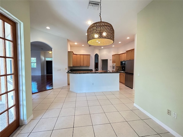 13809 18th Pl E, Bradenton, FL 34212 - kitchen featuring arched walkways, dark countertops, light tile patterned flooring, stainless steel oven, and recessed lighting