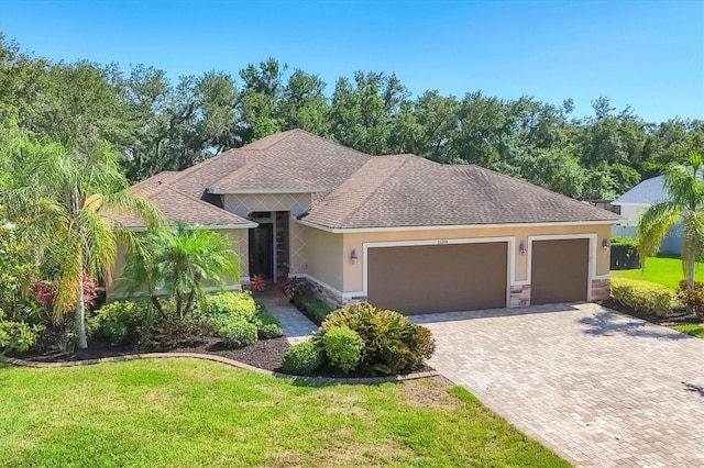 15208 21st Ave E, Bradenton, FL 34212 - ranch-style house featuring a garage, decorative driveway, a front lawn, and stone siding