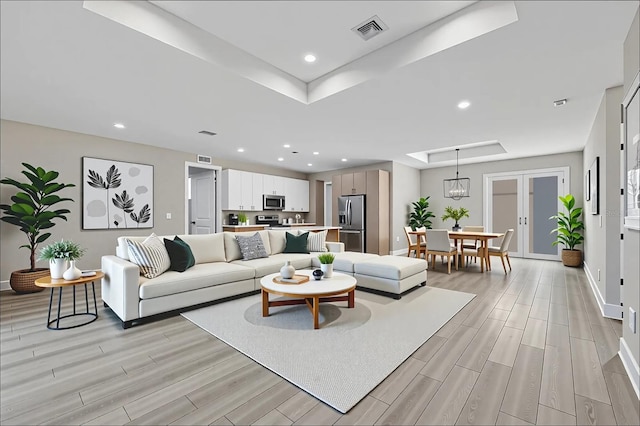2258 Margaret Ln, North Port, FL 34286 - living area featuring a tray ceiling, light wood-style flooring, recessed lighting, and french doors