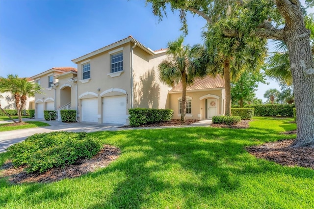 7160 Cedar Hollow Cir, Bradenton, FL 34203 - mediterranean / spanish-style house featuring an attached garage, stucco siding, a tiled roof, driveway, and a front lawn
