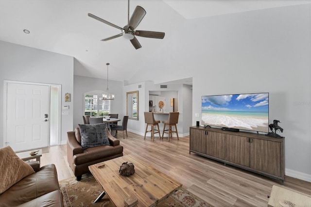 7160 Cedar Hollow Cir, Bradenton, FL 34203 - living room featuring a chandelier, light wood-style flooring, a ceiling fan, high vaulted ceiling, and baseboards