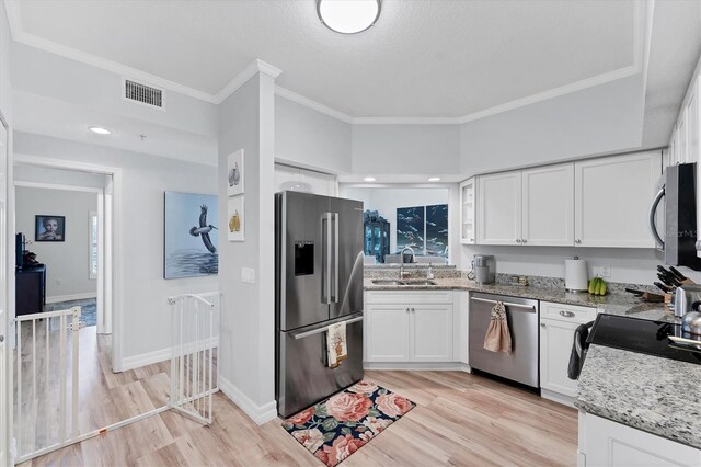 7160 Cedar Hollow Cir, Bradenton, FL 34203 - kitchen with stainless steel appliances, a sink, white cabinets, crown molding, and light wood-style floors