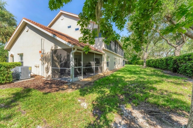 7160 Cedar Hollow Cir, Bradenton, FL 34203 - back of house with central AC, a sunroom, a yard, and stucco siding