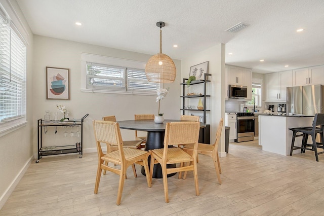 2908 Gulf Dr, Holmes Beach, FL 34217 - dining space with light wood-style floors, healthy amount of natural light, recessed lighting, baseboards, and a textured ceiling
