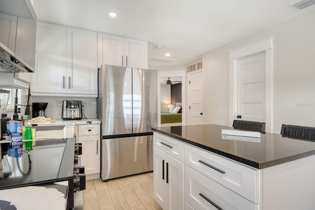2908 Gulf Dr, Holmes Beach, FL 34217 - kitchen with freestanding refrigerator, recessed lighting, white cabinetry, tasteful backsplash, and stove