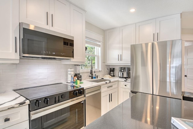 2908 Gulf Dr, Holmes Beach, FL 34217 - kitchen featuring stainless steel appliances, a sink, white cabinets, and recessed lighting