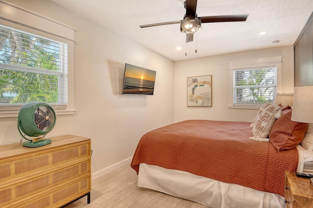 2908 Gulf Dr, Holmes Beach, FL 34217 - bedroom with light wood finished floors, baseboards, a ceiling fan, a textured ceiling, and recessed lighting