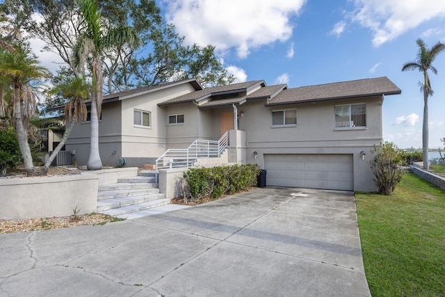5912 Riverview Ln, Bradenton, FL 34209 - view of front facade featuring stucco siding, a garage, driveway, and a front yard