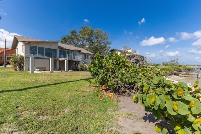 5912 Riverview Ln, Bradenton, FL 34209 - view of green lawn with a sunroom and a water view