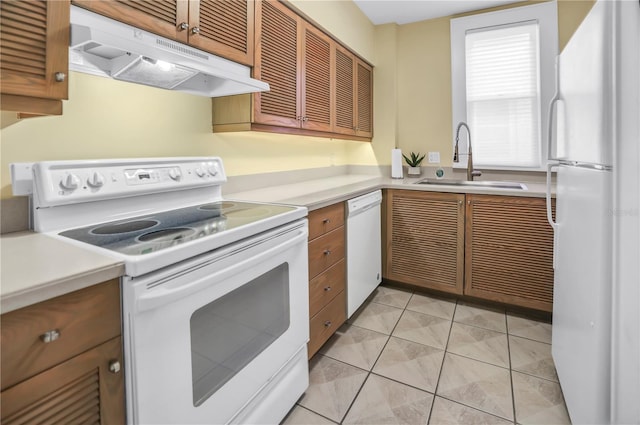 1221 N Palm Ave Unit 303, Sarasota, FL 34236 - kitchen with white appliances, under cabinet range hood, a sink, and light countertops