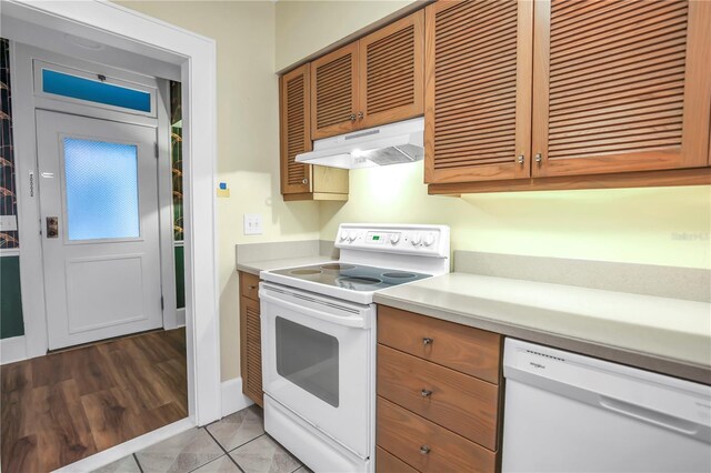 1221 N Palm Ave Unit 303, Sarasota, FL 34236 - kitchen featuring white appliances, under cabinet range hood, light countertops, and brown cabinets