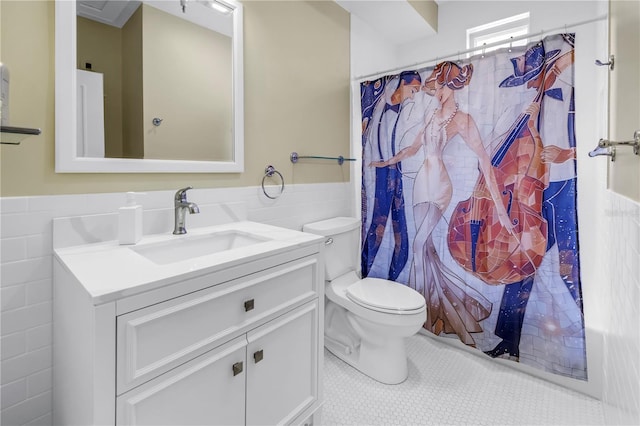 1221 N Palm Ave Unit 303, Sarasota, FL 34236 - bathroom with tile walls, toilet, vanity, wainscoting, and tile patterned floors